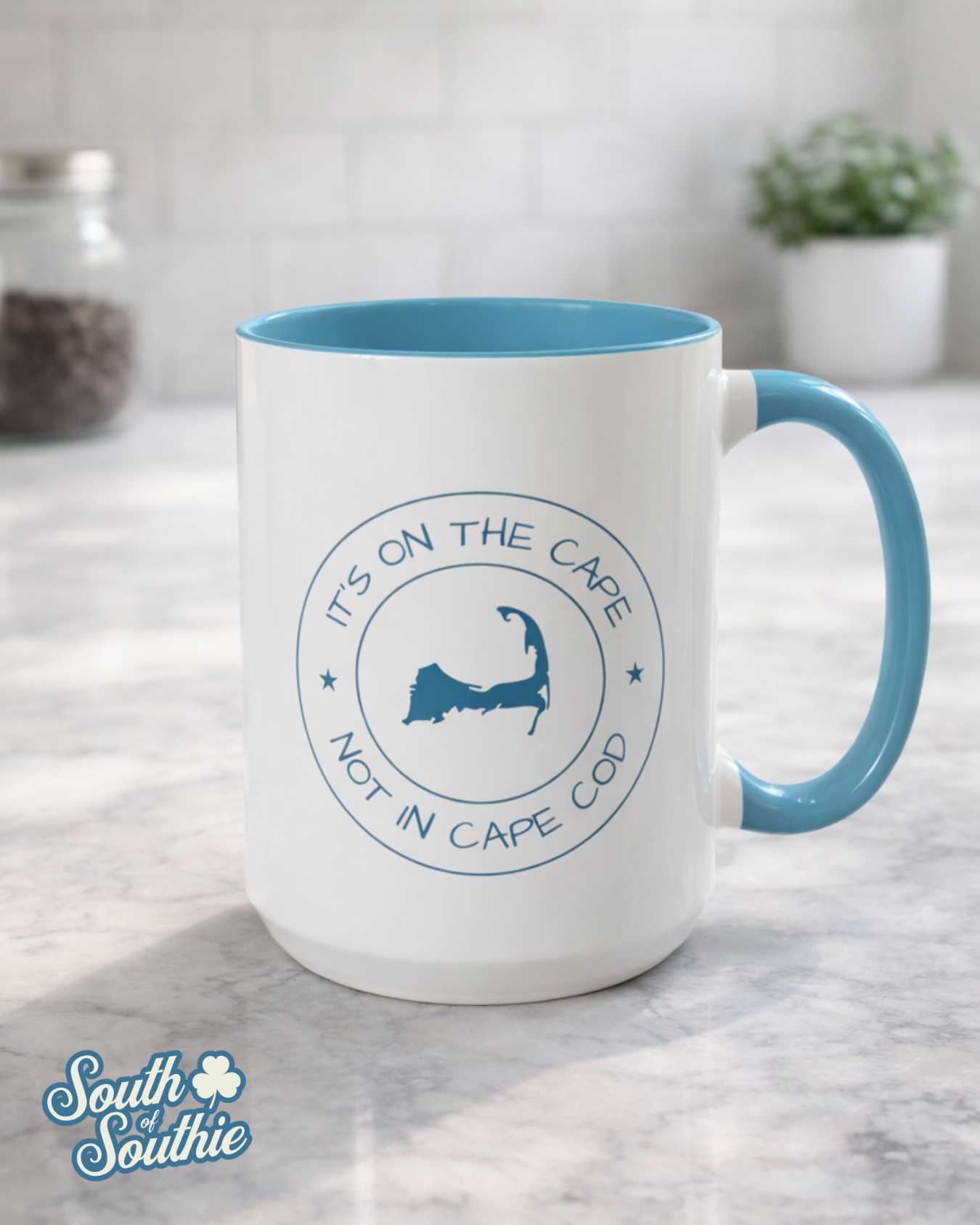 White mug with blue interior and handle, featuring a logo and text, on a marble surface.